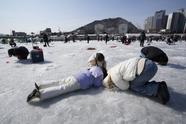 A family member casts a line through a hole drilled in the surface of a frozen river during a trout catching contest in Hwacheon, South Korea, Sunday, February 2, 2025. (Photo by Ahn Young-joon/AP Photo)