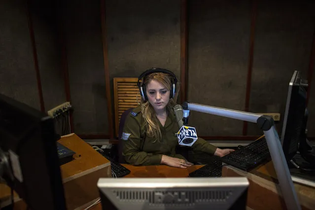 An Israeli soldier from Galei Tzahal, the Israeli army radio station, speaks during a broadcast session at the station's studio in Jaffa, south of central Tel Aviv November 10, 2013. The Israeli military operates two radio stations, a news-based station that started broadcasting in 1950, and Galgalatz, a popular music station marking its 20th anniversary. The stations mostly employ soldiers who work alongside civilian presenters, including leading names in Israeli broadcasting. (Photo by Nir Elias/Reuters)