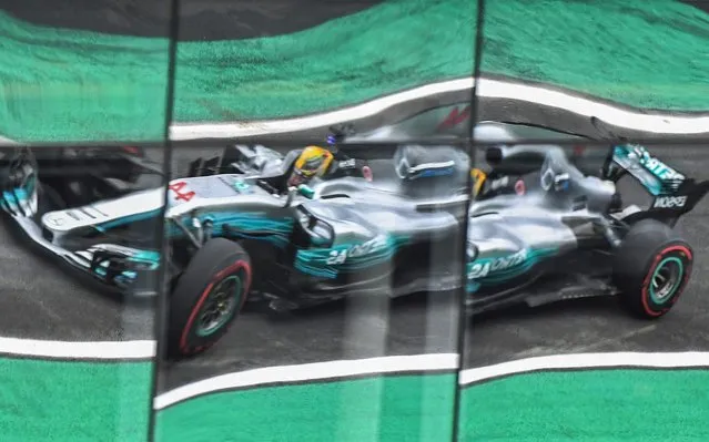 Mercedes' British driver Lewis Hamilton is reflected on windows as he powers his car during the Brazilian Formula One Grand Prix third practice session at the Interlagos circuit in Sao Paulo, Brazil, on November 11, 2017. Hamilton said members of his Mercedes team had guns held to their heads as they were robbed as they left the Interlagos circuit on Friday. “Some of my team were held up at gun point last night leaving the circuit here in Brazil. Gun shots fired, gun held at ones head. This is so upsetting to hear”, world champion Hamilton tweeted. (Photo by Nelson Almeida/AFP Photo)