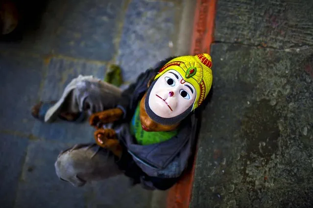 A street child wears a mask of Hindu monkey God Hanuman  re  on a street in Katmandu, Nepal, November 2, 2012. (Photo by Niranjan Shrestha/Associated Press)