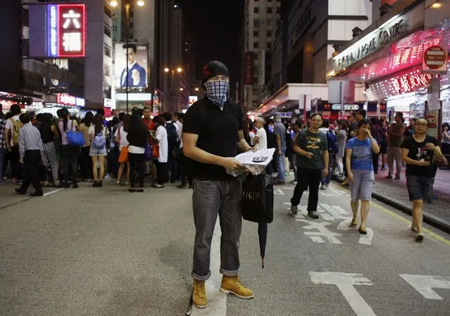 John, who works in design, poses at Mongkok shopping district in Hong Kong October 7, 2014. Showing only his eyes to hide his identity, John said, “I am here to distribute leaflets on democracy, to tell people this movement is not a carnival”. (Photo by Bobby Yip/Reuters)