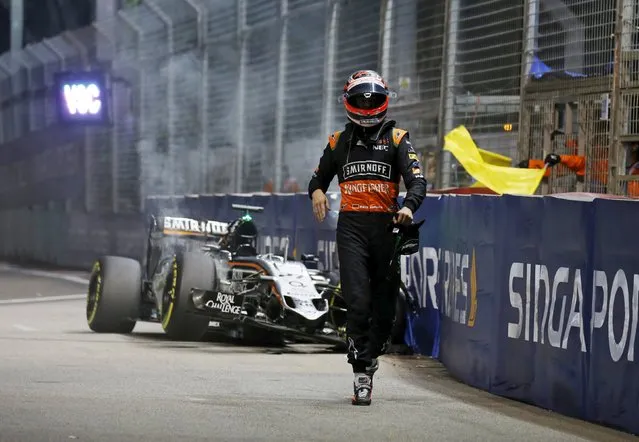 Force India Formula One driver Nico Hulkenberg of Germany walks from his car after crashing during the Singapore F1 Grand Prix at the Marina Bay street circuit September 20, 2015. (Photo by Edgar Su/Reuters)