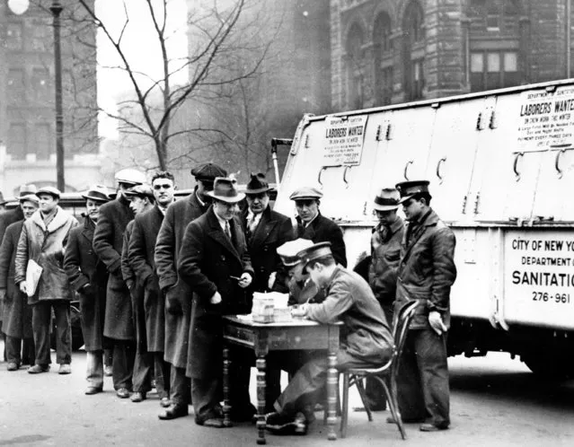 Men line up in front of City Hall to apply for jobs cleaning away snow in New York City on January 3, 1934 during the Great Depression. A sign attached to the parked snow-removal truck reads, “Laborers Wanted”. (Photo by AP Photo)
