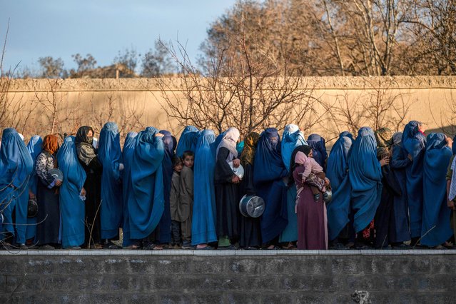 Afghan burqa-clad women wait in a queue to receive free iftar meal during the Islamic holy fasting month of Ramadan, on the outskirts of Kabul on March 12, 2025. (Photo by Wakil Kohsar/AFP Photo)