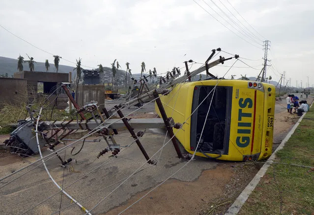 Power lines and a passenger bus are seen after being damaged by strong winds caused by Cyclone Hudhud in Visakhapatnam October 13, 2014. (Photo by R. Narendra/Reuters)