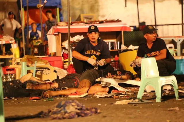 Philippine police investigators check bodies at a blast site at a night market that has left at least several people dead and wounded others in southern Davao city, Philippines late Friday September 2, 2016. The powerful explosion at a night market late Friday in Philippine President Rodrigo Duterte's hometown in the southern Philippines took place amid a security alert due to a major offensive against Abu Sayyaf militants in the region, officials said. (Photo by Manman Dejeto/AP Photo)
