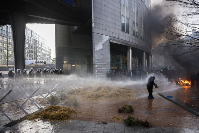 Anti riot police use water to disperse people during a protest by farmers outside the European Parliament as European leaders meet for an EU summit in Brussels, Thursday, February 1, 2024. European Union leaders meet in Brussels for a one day summit to discuss the revision of the Multiannual Financial Framework 2021-2027, including support for Ukraine. (Photo by Thomas Padilla/AP Photo)