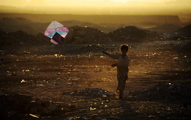 In this photograph taken on October 20, 2014, an Afghan child plays with a kite on the outskirts of Herat. Afghanistan's economy has improved significantly since the fall of the Taliban regime in 2001 largely because of the infusion of international assistance. Despite significant improvement in the last decade the country is still extremely poor and remains highly dependent on foreign aid. (Photo by Aref Karimi/AFP Photo)