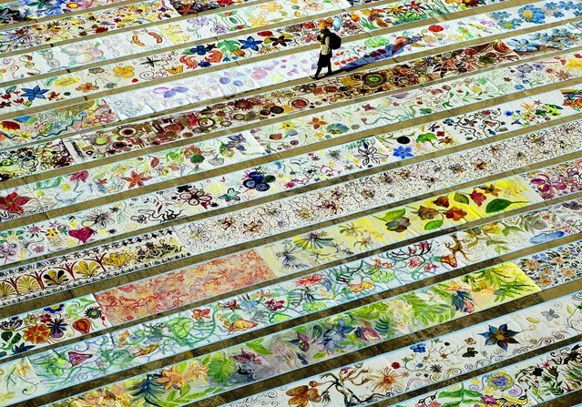 A woman walks by the the world's longest canvas painted by children in Bucharest, Romania, Saturday November 18, 2006 during an UNICEF organized event. Guinness book of World Records representatives attending the event confirmed the record. (Photo by Bogdan Maran/Mediafax/Associated Press)