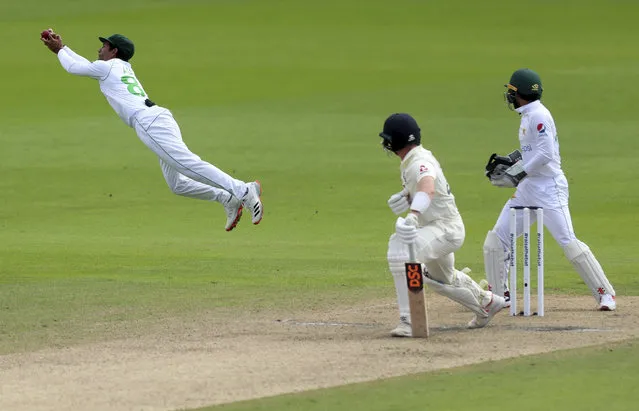 Pakistan's Asad Shafiq, left, dives to catch the ball to dismiss England's Dominic Bess, center, during the third day of the first cricket Test match between England and Pakistan at Old Trafford in Manchester, England, Friday, August 7, 2020. (Photo by Lee Smith/Pool via AP Photo)