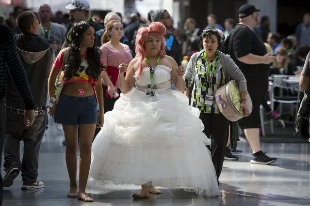 People in costume walk through the New York Comic Con in Manhattan, New York, October 8, 2015. (Photo by Andrew Kelly/Reuters)