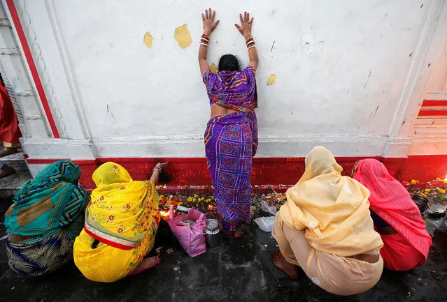 A Hindu woman touches the wall of a temple as other devotees offer prayers during the Maha Shivratri festival in Kolkata, India February 14, 2018. (Photo by Rupak De Chowdhuri/Reuters)