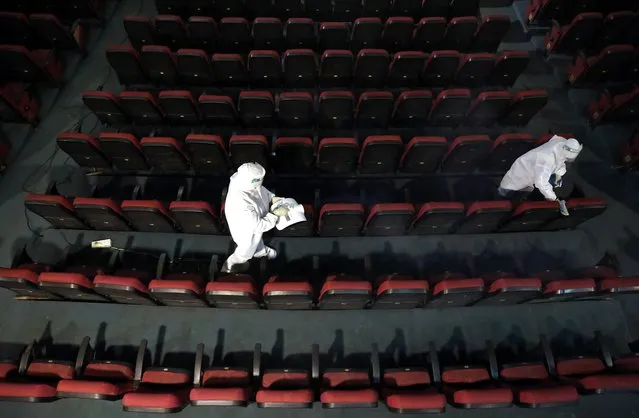 Workers wearing personal protective equipment (PPE) sanitize and clean the seats of Star theatre ahead of its reopening, amidst the outbreak of the coronavirus disease (COVID-19), in Kolkata, India, September 29, 2020. (Photo by Rupak De Chowdhuri/Reuters)