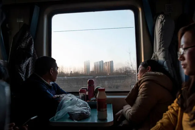 This photo taken on February 10, 2018 shows passengers sitting on a crowded train as it leaves Beijing for the 26- hour journey to Chengdu ahead of the Lunar New Year. China is in the midst of its annual travel rush as millions head to their hometowns to enjoy a week- long holiday. The Lunar New Year begins on February 16, and authorities expect more than 390 million train trips to take place between February 1 and March 12. (Photo by Fred Dufour/AFP Photo)