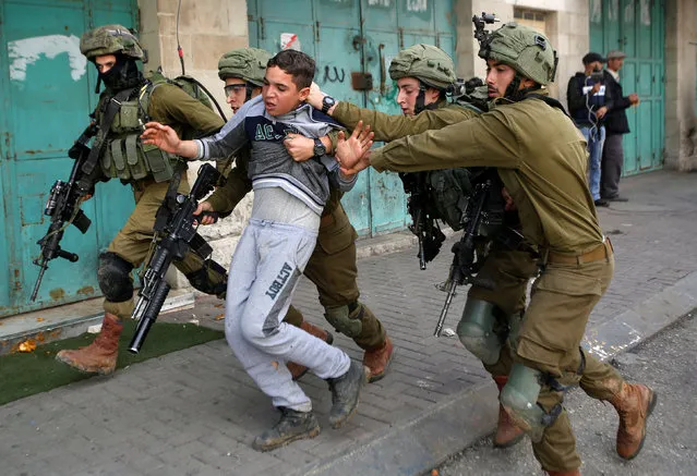 Israeli soldiers detain a Palestinian during clashes at a protest in Hebron, in the occupied West Bank February 23, 2018. (Photo by Mussa Qawasma/Reuters)