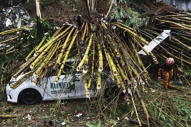 An emergency service worker clear debris caused by Storm Wipha's  monsoon rains in Quezon City, Metro Manila, Philippines 23 July 2025. According to the National Disaster Risk Reduction and Management Council (NDRRMC), multiple cities and municipalities across the country have declared a state of calamity after storm Wipha caused consecutive days of monsoon rain. (Photo by Rolex Dela Pena/EPA)