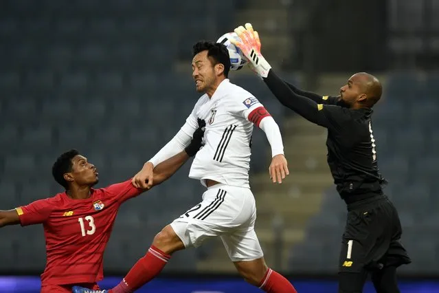 Japan's Maya Yoshida, center, jumps for the ball as Panama's goalkeeper Luis Me Jia, right, makes a save and Oscar Linton pushes him during the international friendly soccer match between Japan and Panama at Merkur-Arena stadium in Graz, Austria, Friday, November 13, 2020. (Photo by Andreas Schaad/AP Photo)