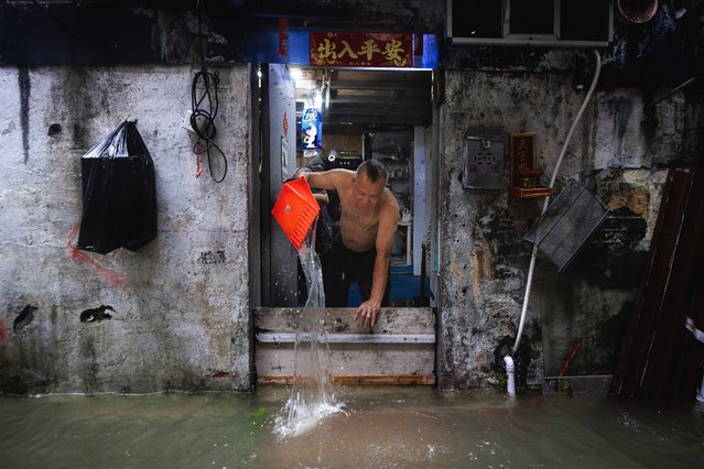 A man bails water from his flooded house during the passage of Super Typhoon Ragasa in Macau on September 24, 2025. Fierce winds, pounding rain and high seas battered Hong Kong on September 24 as Super Typhoon Ragasa headed into southern China after causing a lake burst that killed at least 14 people in Taiwan. (Photo by Eduardo Leal/AFP Photo)
