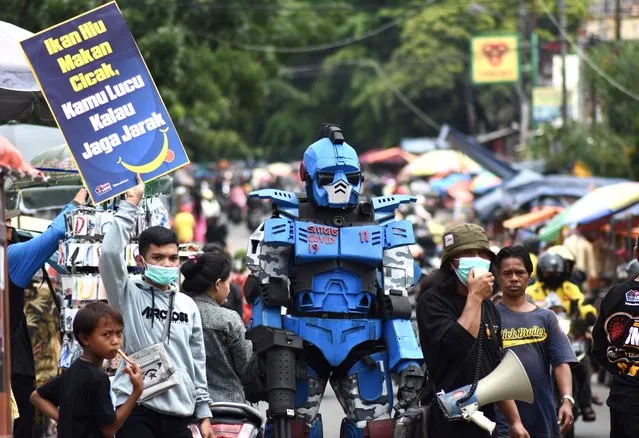 An activist wearing a robot campaigns to encourage residents to wear face masks amid the Covid-19 coronavirus pandemic in Bandung on November 15, 2020. (Photo by Timur Matahari/AFP Photo)