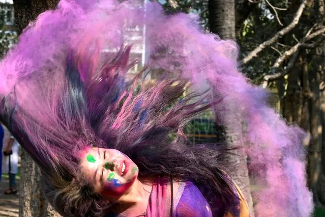 A woman smeared with “Gulal” or coloured powder during celebrations of Hindu spring festival “Holi” in Kolkata, India on March 7, 2023. (Photo by Dibyangshu Sarkar/AFP Photo)