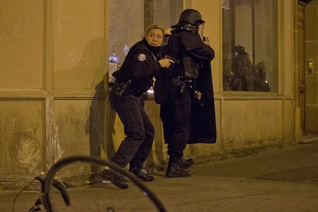 French police secure the perimeter after panic broke out among mourners who payed their respect at the attack sites at restaurant Le Petit Cambodge (Little Cambodia) and the Carillon Hotel in Paris, Sunday, November 15, 2015. Thousands of French troops deployed around Paris on Sunday and tourist sites stood shuttered in one of the most visited cities on Earth while investigators questioned the relatives of a suspected suicide bomber involved in the country's deadliest violence since World War II. (Photo by Peter Dejong/AP Photo)