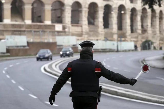 Italian Carabinieri officers check vehicles near the Colosseum in Rome, Thursday, December 24, 2020. Italians are easing into a holiday season full of restrictions, and already are barred from traveling to other regions except for valid reasons like work or health. Starting Christmas eve, travel beyond city or town borders also will be blocked, with some allowance for very limited personal visits in the same region. (Photo by Gregorio Borgia/AP Photo)
