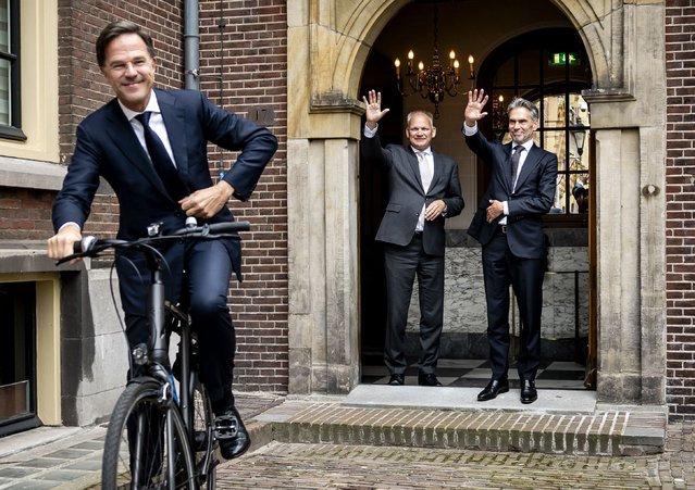 Newly-appointed Dutch Prime Minister Dick Schoof (R) waves to former Prime Minister Mark Rutte (L) leaving on his bike after a handover ceremony at the Torentje in The Hague, on July 2, 2024. Former spy chief Dick Schoof becomes the new Dutch prime minister on July 2, leading a right-wing coalition cabinet on a mission to implement the "strictest-ever" immigration policy in the country. Two hundred and twenty-three days after far-right leader Geert Wilders swept to an election victory that stunned Europe and the world, Schoof takes over from Mark Rutte after 14 years in power. (Photo by Remko de Waal/ANP via AFP)