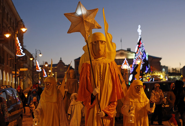 People parade through the streets as part of celebrations of Three Kings Day in downtown Vilnius, Lithuania, Tuesday, January 6, 2015. Epiphany, the 12th night of Christmas, marks the day the three wise men visited Christ. (Photo by Mindaugas Kulbis/AP Photo)