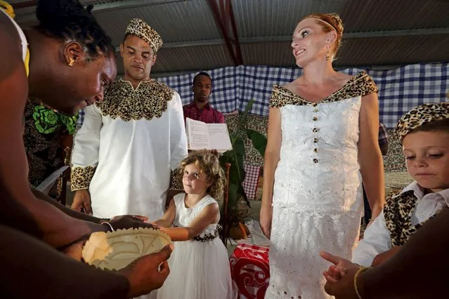The children of Dutch migrants Reggio de Jong (L) and Elisabeth Cobben have their hands washed during their parents' wedding ceremony in the second public marriage ever held under the African-American Winti religion in district Para, Suriname, November 18, 2015. (Photo by Ranu Abhelakh/Reuters)
