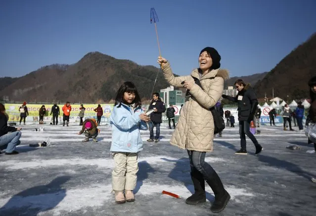 A Japanese woman enjoys fishing for trout through a hole with her daughter in a frozen river in Hwacheon, about 20 km (12 miles) south of the demilitarized zone separating the two Koreas, January 10, 2015. (Photo by Kim Hong-Ji/Reuters)