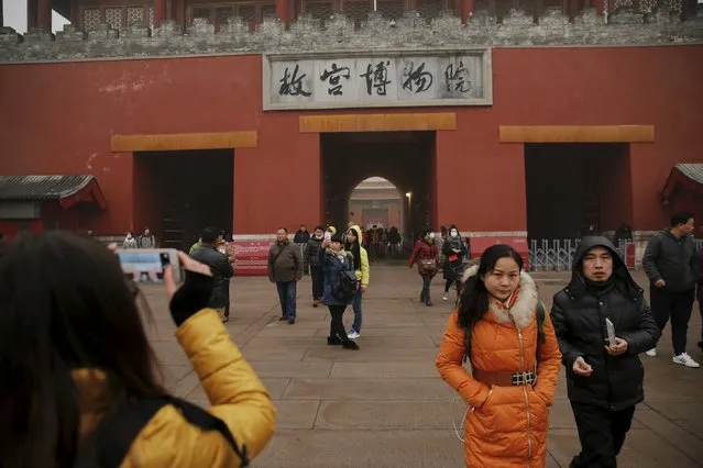 People leave the Forbidden City on an extremely polluted day as hazardous, choking smog continues to blanket Beijing, China December 1, 2015. (Photo by Damir Sagolj/Reuters)