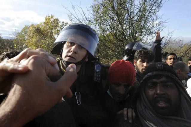 Macedonian police officers block stranded migrants trying to cross the Greek-Macedonian border, near Gevgelija, Macedonia December 2, 2015. Picture taken from the Greek side of the border. (Photo by Alexandros Avramidis/Reuters)