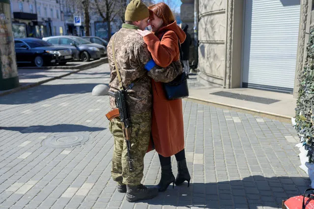 Igor, a 40 year-old Ukranian soldier embraces his wife in front of his military basement in the center of Odessa on March 17, 2022. Odessa, which Ukraine fears could be the next target of Russia's offensive in the south, is the country's main port and is vital for its economy. But the city of one million people close to the Romanian and Moldovan borders also holds a special place in the Russian imagination. (Photo by Bulent Kilic/AFP Photo)