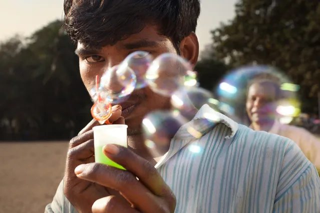 “Bubbles”. A man blowing bubbles on the beach shares a moment, allowing me a couple seconds to play with the composition of the pedestrians behind him. Location: Mumbai, India. (Photo and caption by Chris Mumma/National Geographic Traveler Photo Contest)
