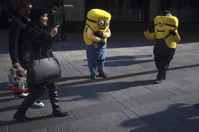 People dressed as Minions, who pose in photos for tips, stand in the sunlight in Times Square in the Manhattan borough of New York January 17, 2015. (Photo by Carlo Allegri/Reuters)