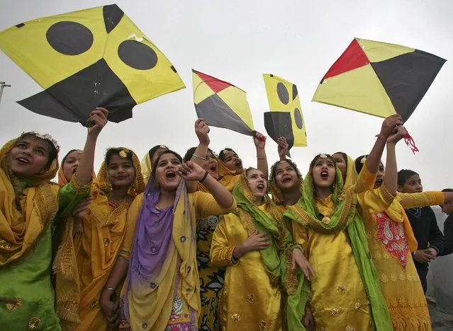 Schoolgirls wearing colourful dresses cheer as they prepare to fly kites during an event to mark the Basant or spring festival in the northern Indian city of Amritsar January 23, 2015. Basant is celebrated mainly in the Indian states of Haryana and Punjab and marks the start of the spring season. (Photo by Munish Sharma/Reuters)