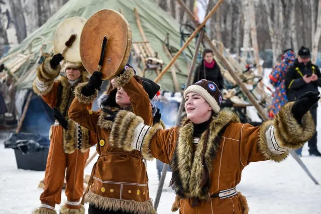 Women wearing traditional dress of peoples of the North perform at an ethnic village opened as part of the 2021 Beringia Winter Festival in Petropavlovsk-Kamchatsky, Russia on February 22, 2021. The Beringia traditional sled dog race has been held in Russia's Kamchatka Territory since 1990. Participants complete a route of around 1,000 km in severe weather conditions. (Photo by Yuri Smityuk/TASS)
