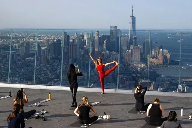 People participate in the 'Sky High' yoga class on the 1,131 feet tall, 100th story, outdoor observation deck at The Edge, Hudson Yards on May 17, 2023 in New York City. Sky High Yoga is a summer partnership between Equinox and The Edge that brings yoga to the outdoor deck once a week with two early morning time slots. The classes, which are open to the public and Equinox members began on May 17th. (Photo by Alexi Rosenfeld/Getty Images)