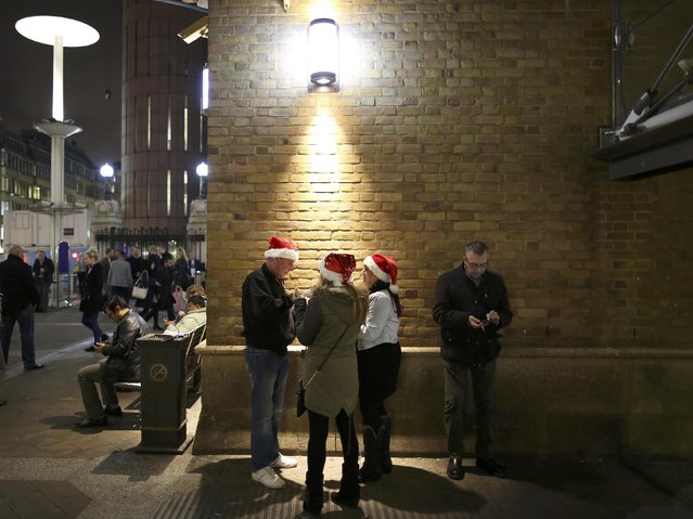 Passengers gather outside Liverpool Street station in London during the Christmas party season, December 18, 2015. (Photo by Paul Hackett/Reuters)