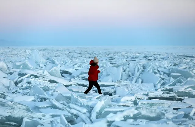 A woman walks through chunks of ice on the frozen Kapchagay reservoir outside Almaty, Kazakhstan on January 14, 2021. (Photo by Pavel Mikheyev/Reuters)