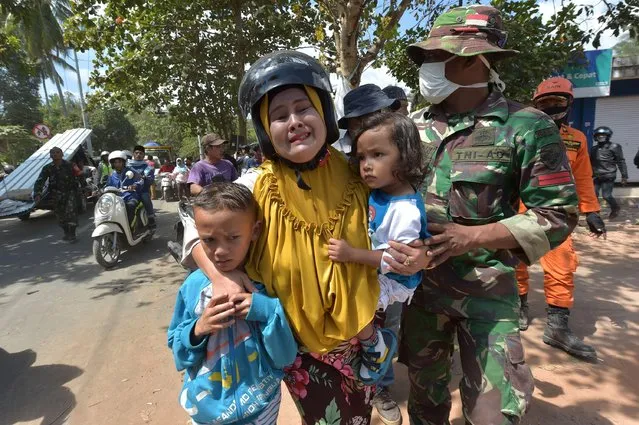 An Indonesian woman cries next to her childern shortly after an aftershock hits the area in Tanjung on Lombok island on August 9, 2018. A strong aftershock struck Indonesia' s Lombok on August 9, causing panic among evacuees sheltering after a devastating earthquake killed more than 160 on the holiday island four days earlier. (Photo by Adek Berry/AFP Photo)