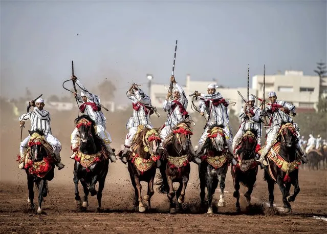 Horse riders perform during the historic equestrian representation called “Tbourida” in Rabat, the capital city of Morocco, on August 12, 2023. Tbourida, UNESCO intangible cultural heritage dating back to the sixteenth century in Morocco, simulates a succession of military parades reconstructed according to ancestral conventions and rituals. In Tbourida, horses race for about 100 meters and performances end with a shot in the air. (Photo by Abu Adem Muhammed/Anadolu Agency via Getty Images)