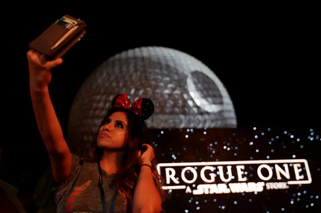 A guest takes a selfie as the Spaceship Earth is turned into the Death Star via projectors in advance of the release of the new Star Wars movie “Rogue One”, at the Walt Disney World's Epcot Center in Lake Buena Vista, Florida, U.S. December 5, 2016. (Photo by Scott Audette/Reuters)
