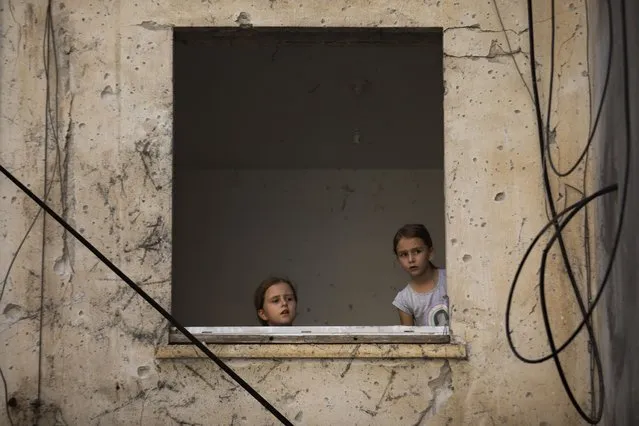 Arina Klochkov, 7, right, and her sister Zoya visit their damaged home after last week it was hit by a rocket fired from the Gaza Strip, in Petah Tikva, central Israel, Friday, May 21, 2021. (Photo by Oded Balilty/AP Photo)