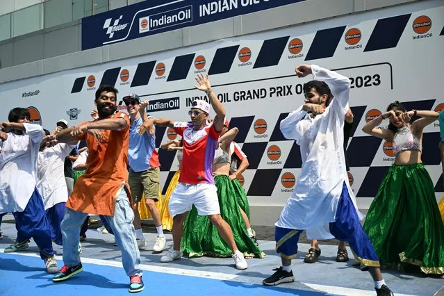 Prima Pramac Racing's Spanish rider Jorge Martin (C) and Gresini Racing MotoGP's Spanish rider Alex Marquez (center L) dance with Indian performers ahead of the Indian MotoGP Grand Prix at the Buddh International Circuit in Greater Noida on the outskirts of New Delhi, on September 21, 2023. (Photo by Money Sharma/AFP Photo)