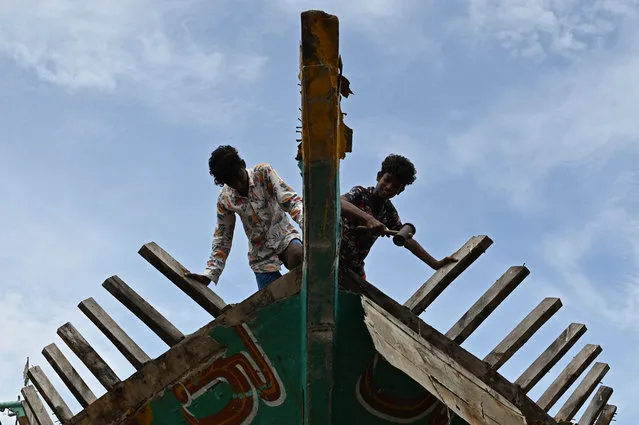 Workers carry out maintenance work on a fishing vessel at Kasimedu fishing harbour after the government eased a lockdown imposed as a preventive measure against the Covid-19 coronavirus in Chennai on June 10, 2021. (Photo by Arun Sankar/AFP Photo)