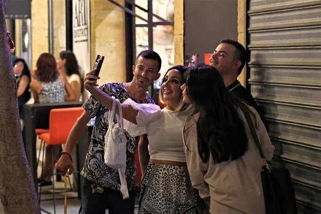 People take a picture in the historic Gemmayzeh district, which had been badly damaged in Beirut's port blast, on August 3, 2023. One of history's biggest non-nuclear explosions rocked Beirut on August 4, 2020, destroying swathes of the Lebanese capital, killing more than 220 people and injuring at least 6,500. Three years on, the probe into the traumatic disaster remains bogged down in legal and political wrangling, to the dismay of victims' families. (Photo by Joseph Eid/AFP Photo)