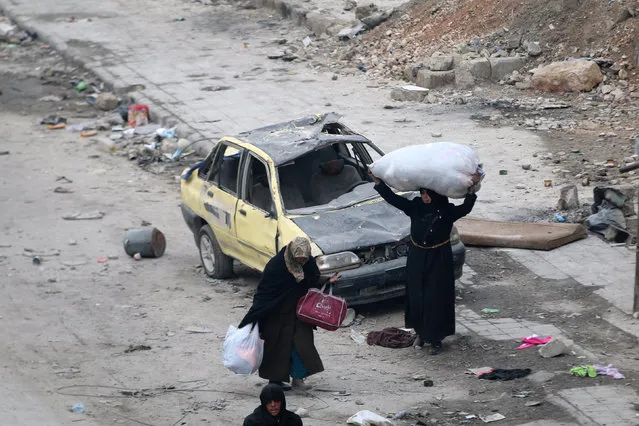 Women carry their belongings as they wait to be evacuated from a rebel-held sector of eastern Aleppo, Syria December 18, 2016. (Photo by Abdalrhman Ismail/Reuters)