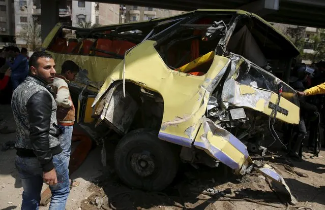 People look at the wreckage of a bus transporting Orascom employees which fell into a roadside canal in Mariouteya river channel at Giza, on the outskirts of Cairo, March 21, 2015. At least 10 people were killed on Saturday when their work bus slipped into the river canal in Giza's Haram district, according to the health ministry. (Photo by Amr Abdallah Dalsh/Reuters)