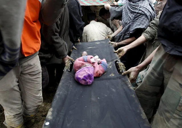 The body of a child lies on a stretcher after it was pulled out from the rubble after a hillside collapsed onto a house at Laden village, west of Srinagar, March 30, 2015. (Photo by Danish Ismail/Reuters)